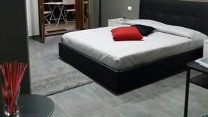 Un dormitorio con cama, mesita de noche y un cuadro en la pared.
