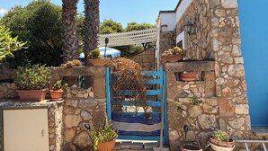 A stone wall with potted plants, a blue gate, and a white building. - Villa CARLOTTA Magnificent Ancient CASEDDHU by the sea (Racale Torresuda)