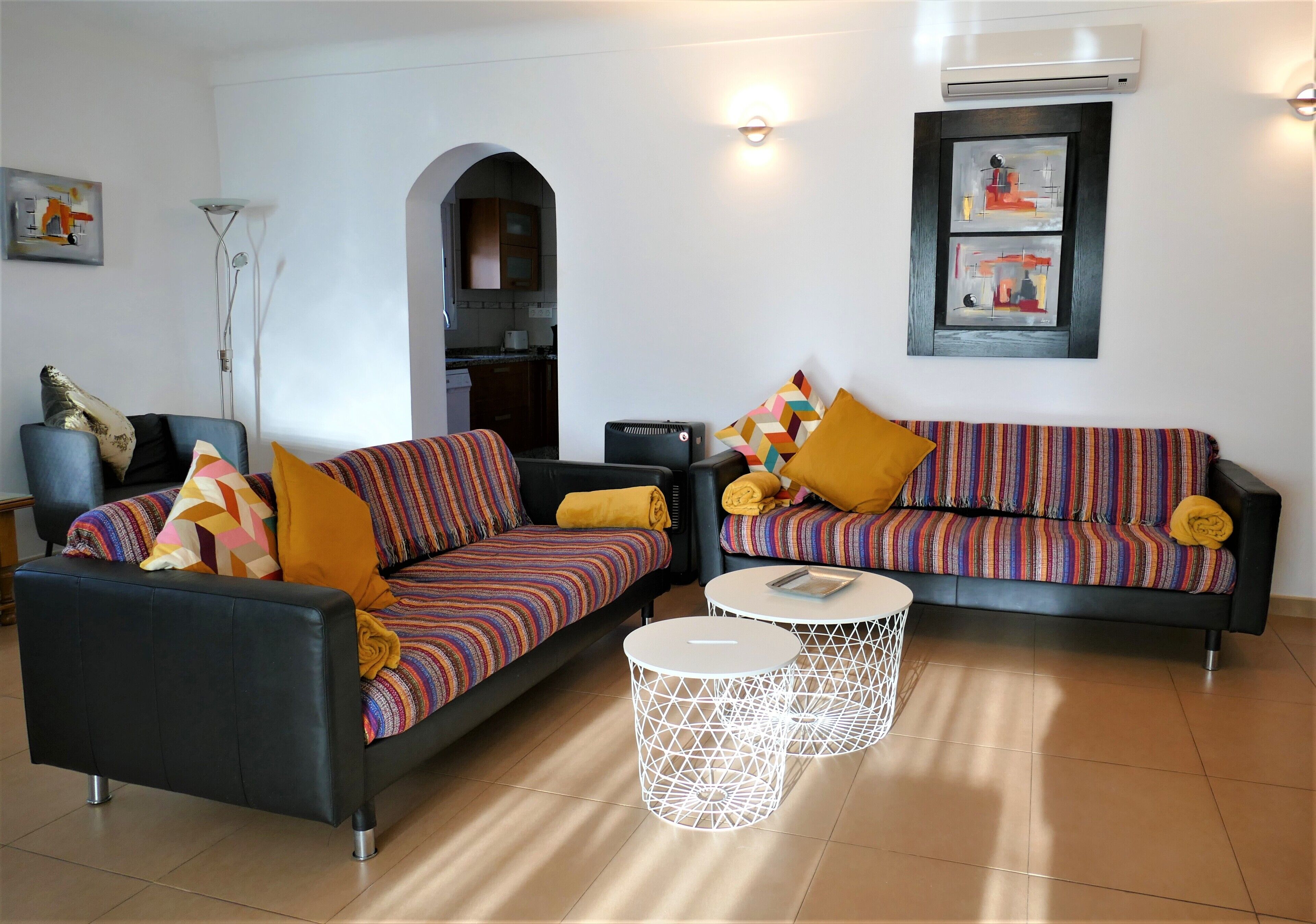 Ein Wohnzimmer mit zwei Sofas, einem Couchtisch und einer Klimaanlage.