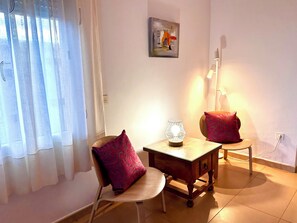 A room with a chair, a small table, a lamp, and a painting on the wall. - El Descanso - by Costadelsolholiday  FAMILY VILLA BY MARINA heated private pool! (Benalmadena Costa)