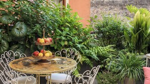 A round table with chairs, a potted plant, and a building with a tower in the background. - La Dolce Vita Boutique Apartment • Elegant • Terrace • Ponte Pietra (VERONA)
