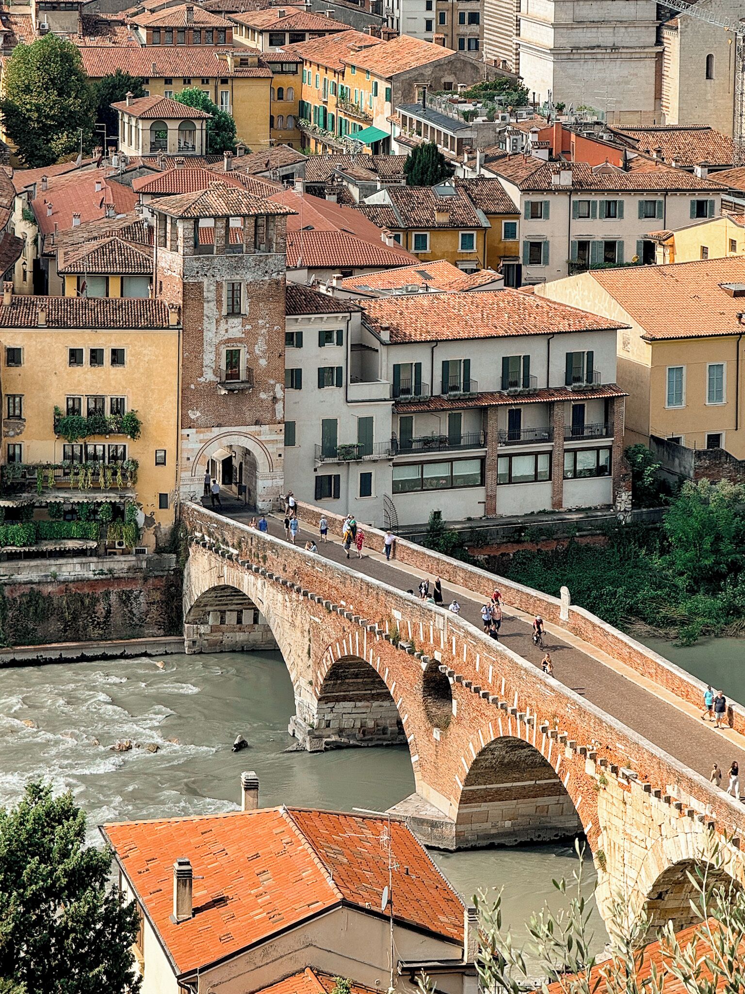 Un pont de pierre à arches enjambant une rivière, entouré de bâtiments historiques aux toits de tuiles.