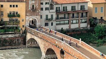 Un pont de pierre à arches enjambant une rivière, entouré de bâtiments historiques aux toits de tuiles.