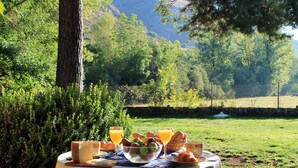 A table set outdoors with a view of a mountainous landscape.
