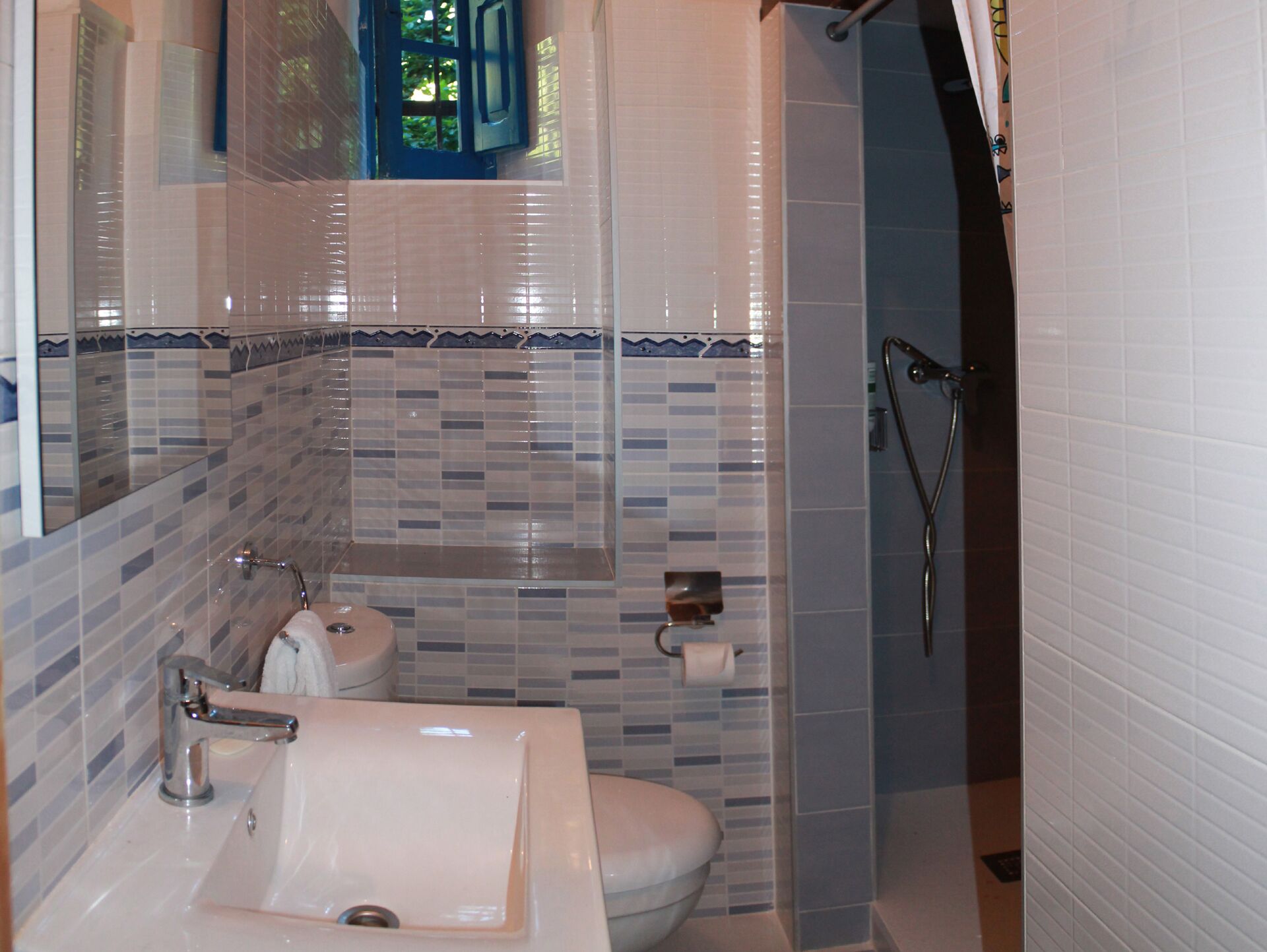 Een bad/douchecombinatie, handdoeken, zeep, shampoo