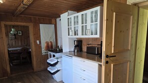 A compact kitchen with white cabinets, a coffee maker, and a toaster. - Ellmau: Quaint holiday home, 350 m to the mountain railway in the mountain doctor village (Ellmau)