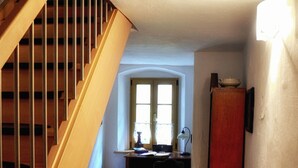 A wooden staircase leading to a room with a desk, a window, and a refrigerator. - modern equipment in historic walls (Görlitz)