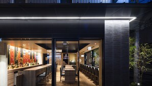 Un bar moderno con una barra larga y zona de asientos.