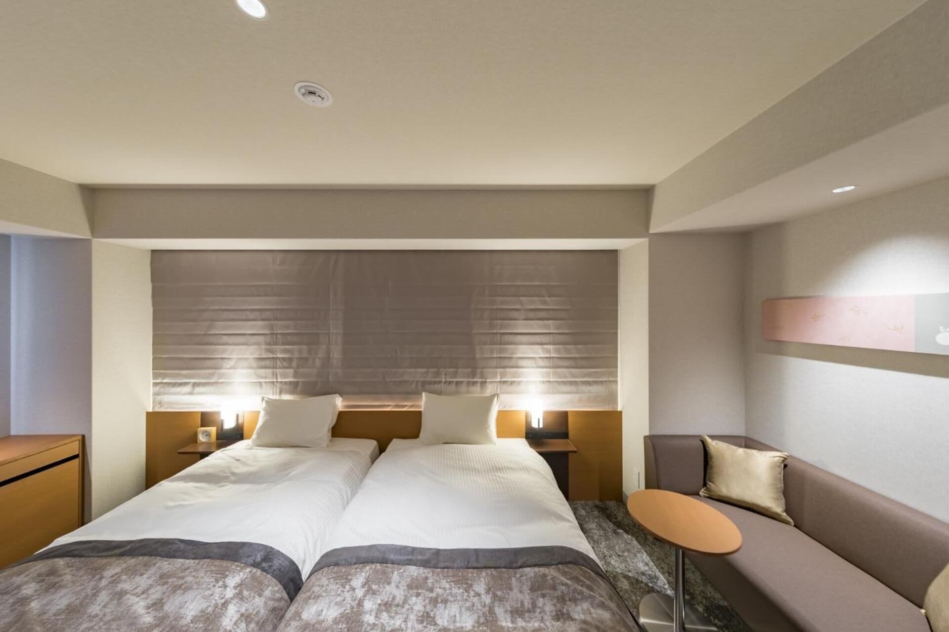 A double bed with two bedside tables, a sofa, and a small table.