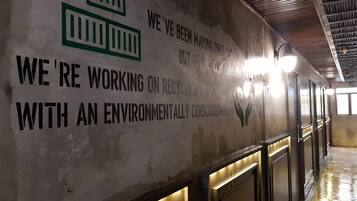 Un pasillo con un panel que muestra información sobre reciclaje y conciencia ambiental.