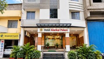 A multi-story hotel with a modern facade, a prominent entrance, and a flag.