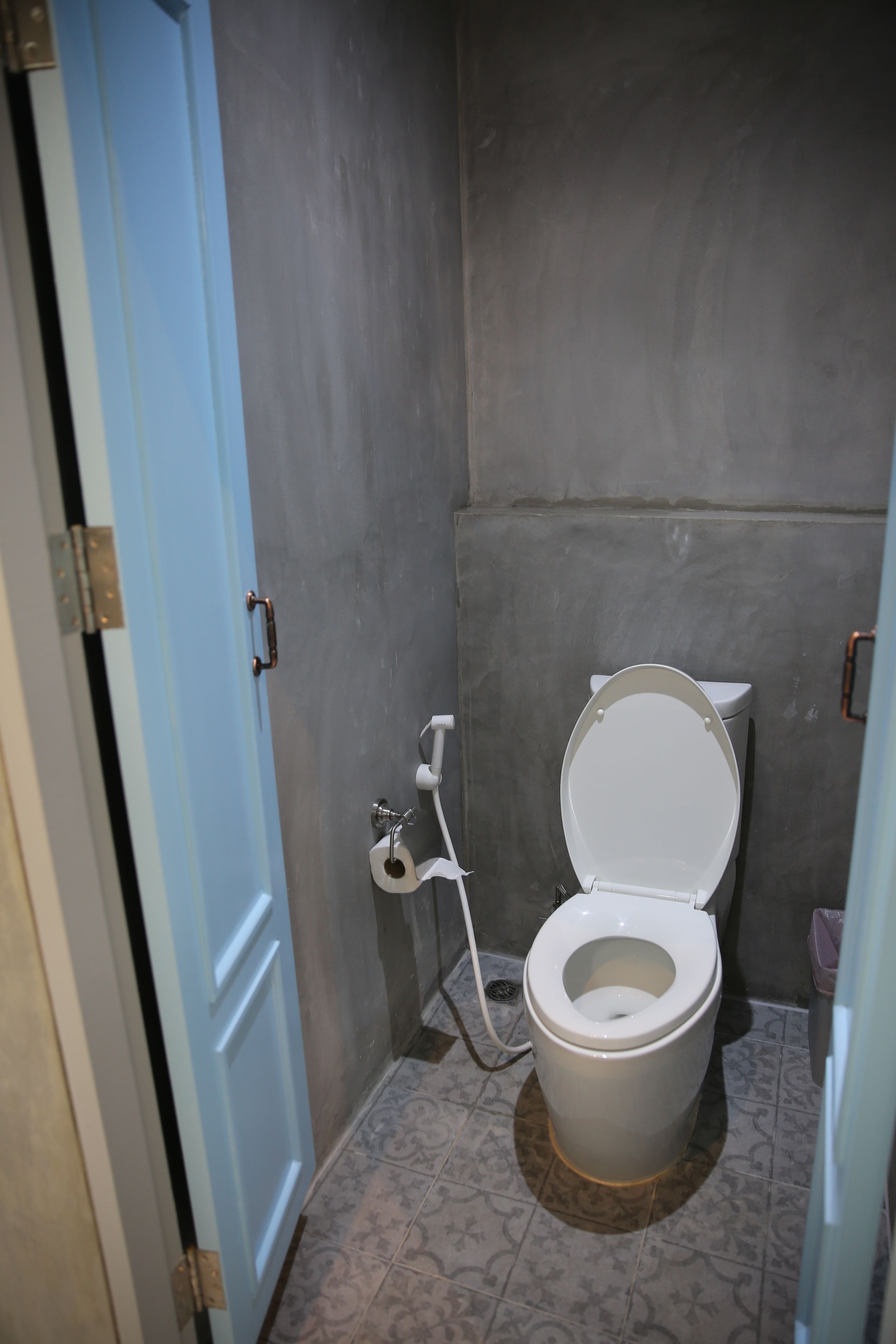 A small bathroom with a toilet, a door, and a wall.