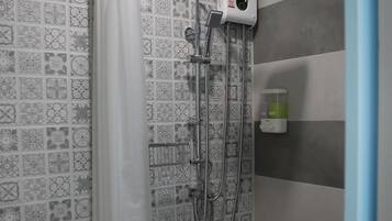 A bathroom with a shower, toilet, and patterned tiles.