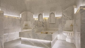 Enjoy a luxurious bathing experience in this spacious bathroom featuring a bathtub and elegant pedestal sink.