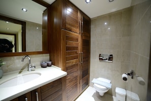 Une salle de bain moderne avec un meuble-lavabo en bois, un évier, des toilettes et un miroir.