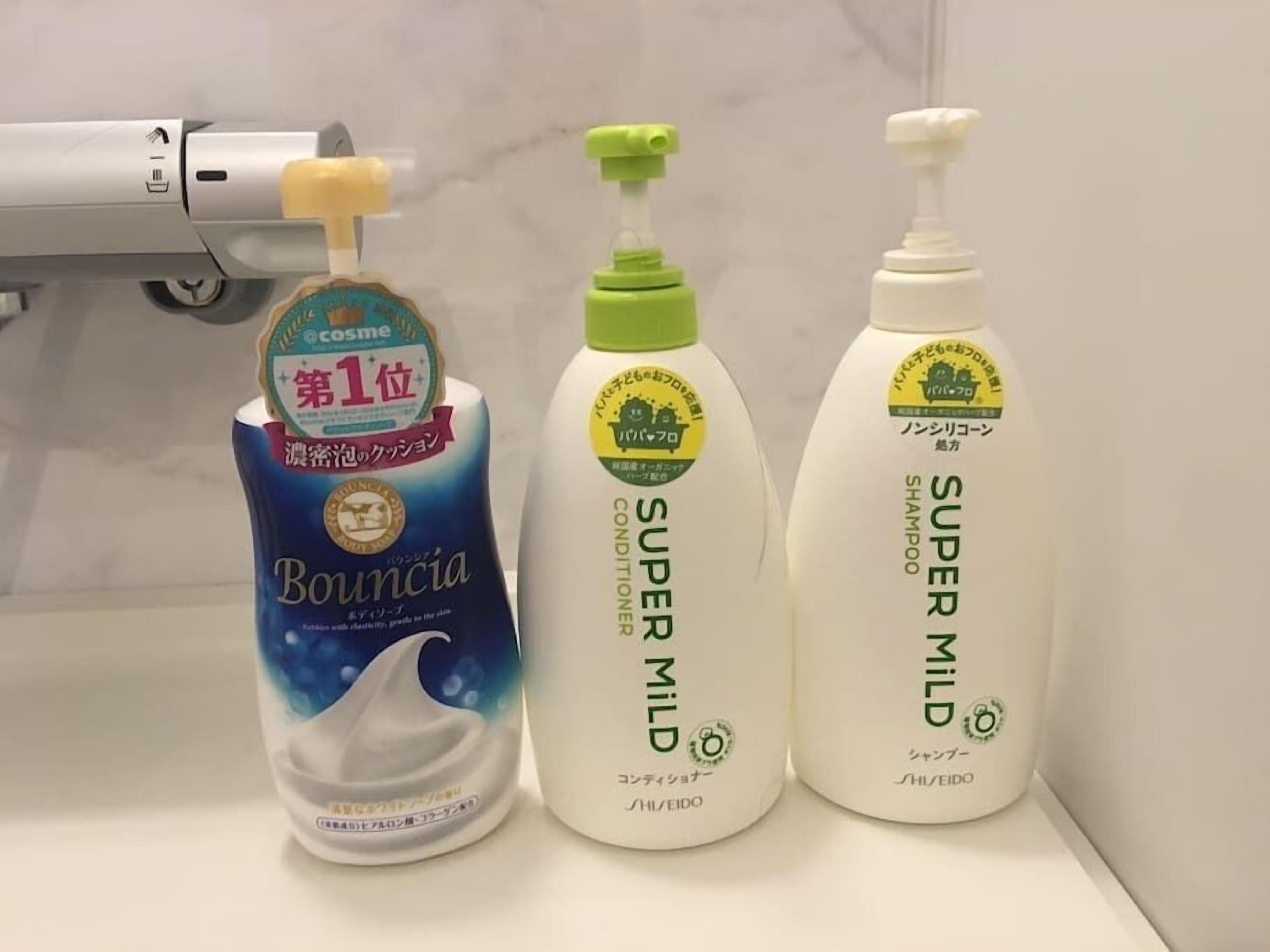 Three bottles of hair care products on a bathroom counter.
