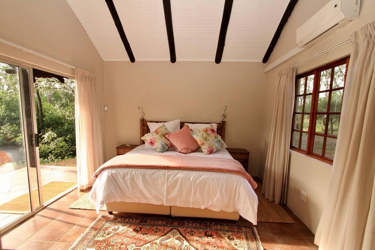 Une chambre à coucher avec un lit, une fenêtre et une porte donnant sur un balcon.