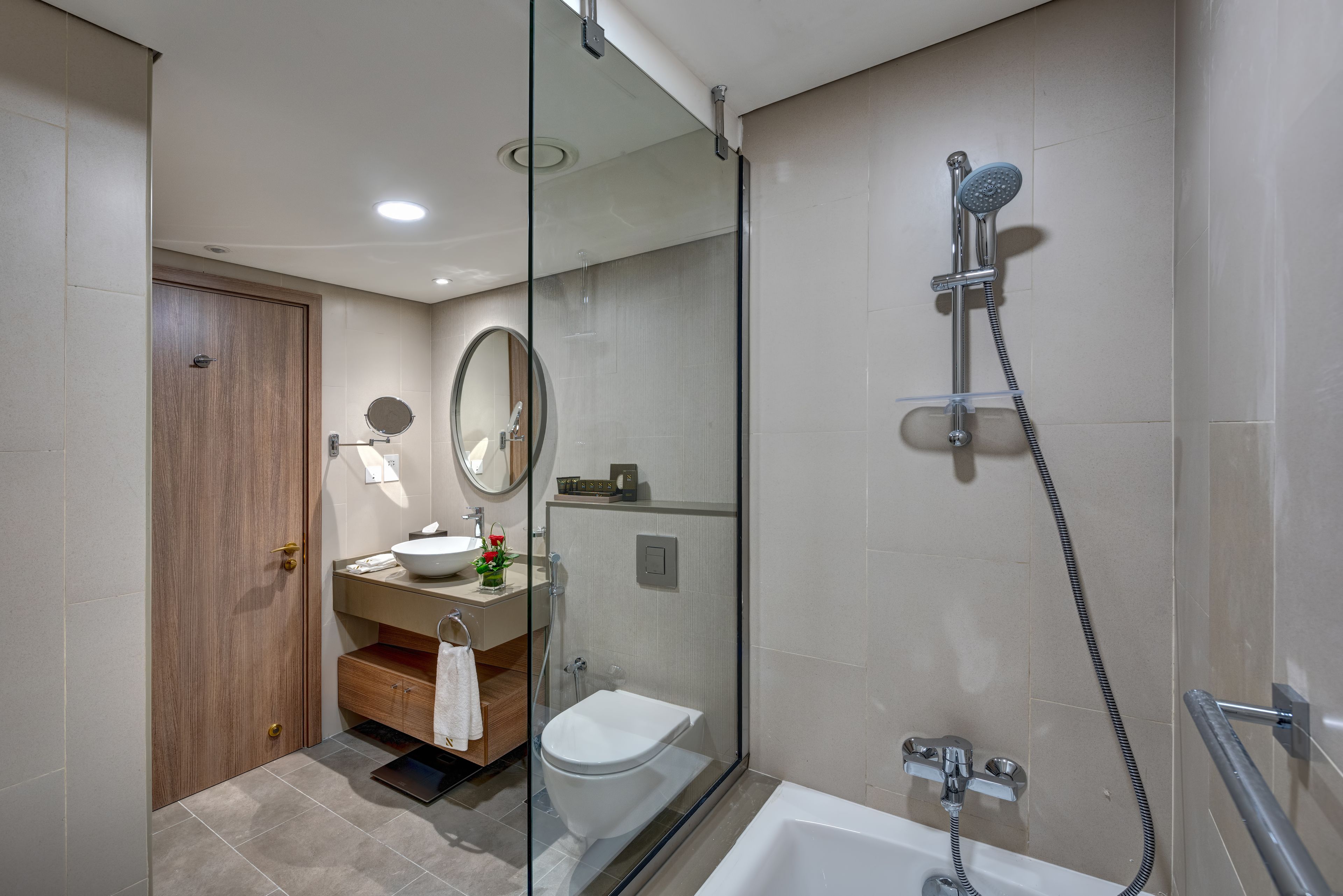 Une salle de bain moderne dotée d’une douche à parois de verre, d’une baignoire et d’un meuble-lavabo avec un évier et un miroir.