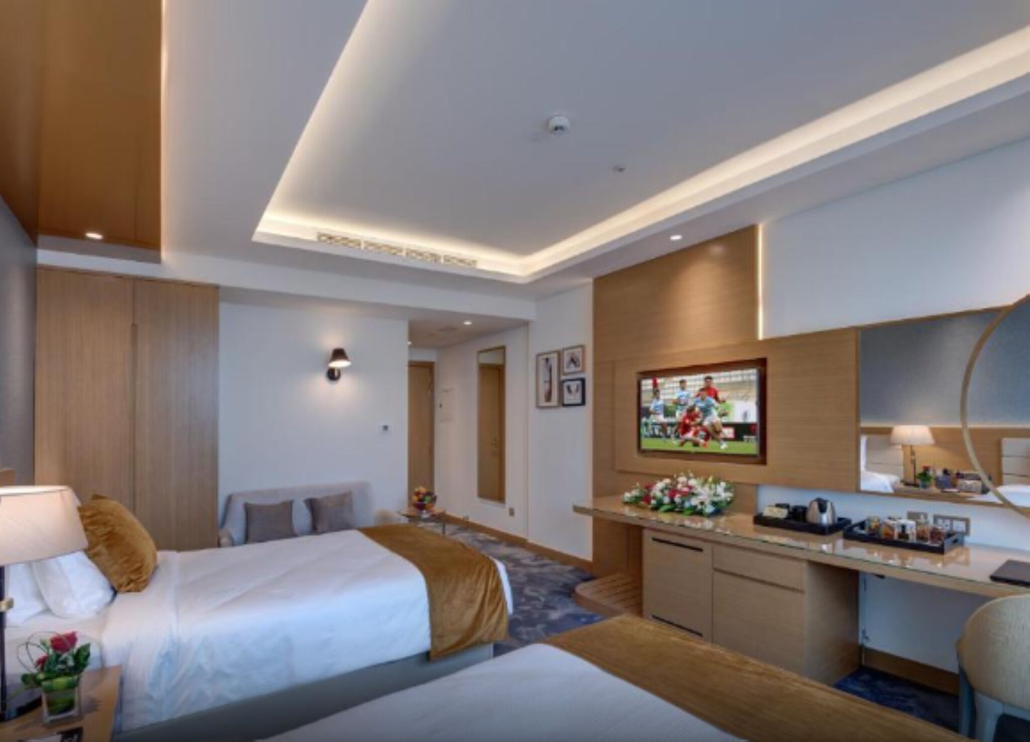 A hotel room with a bed, a desk, a TV, and a bathroom.