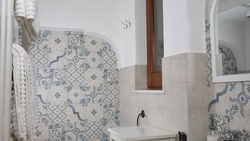 A bathroom with a white sink, a mirror, and a toilet.
