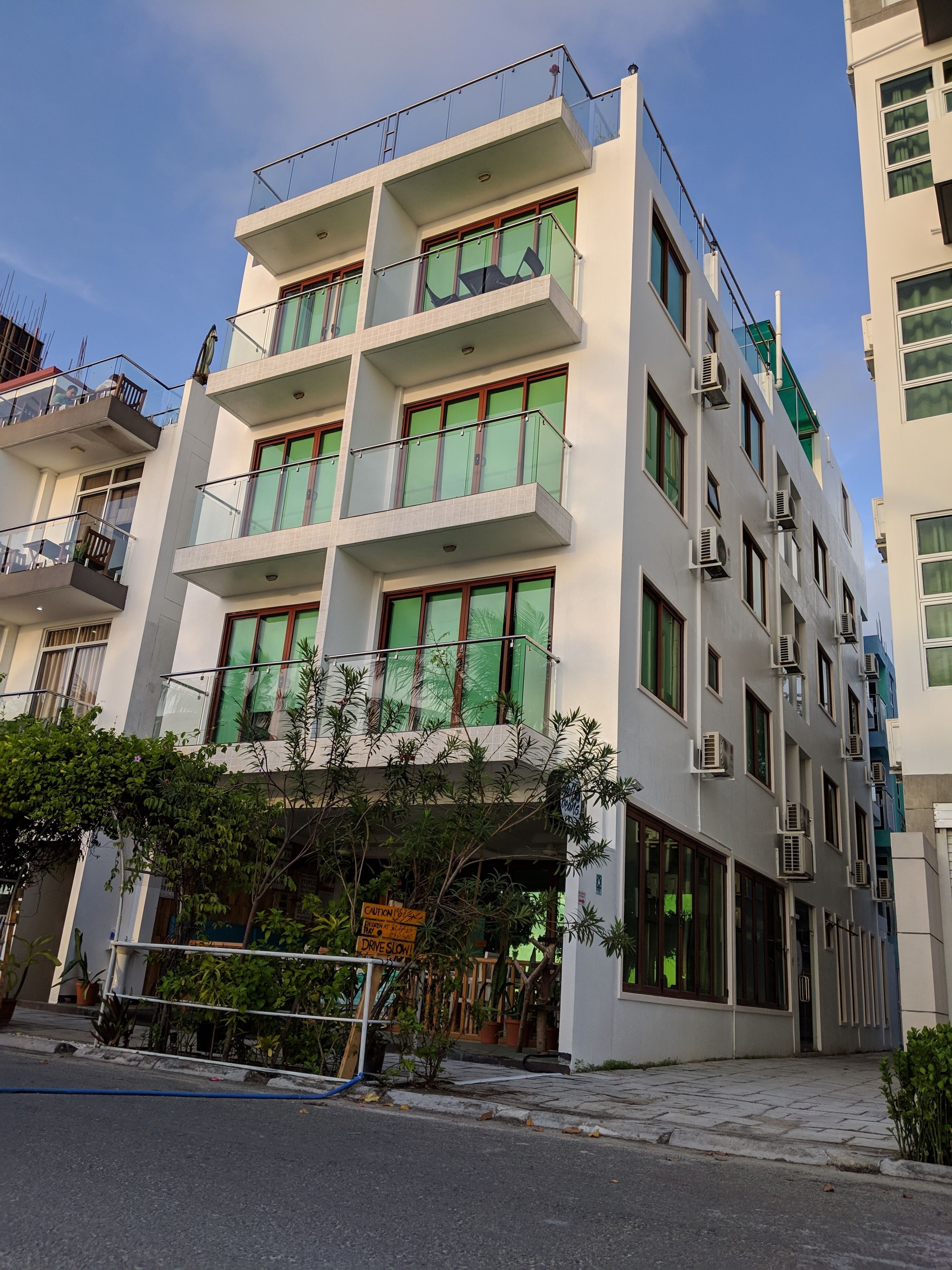 A multi-story building with balconies, large windows, and air conditioning units.