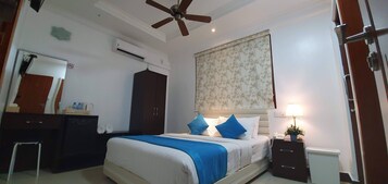 Camera da letto con un letto, una scrivania, un armadio, una ventola a soffitto e un condizionatore d'aria.