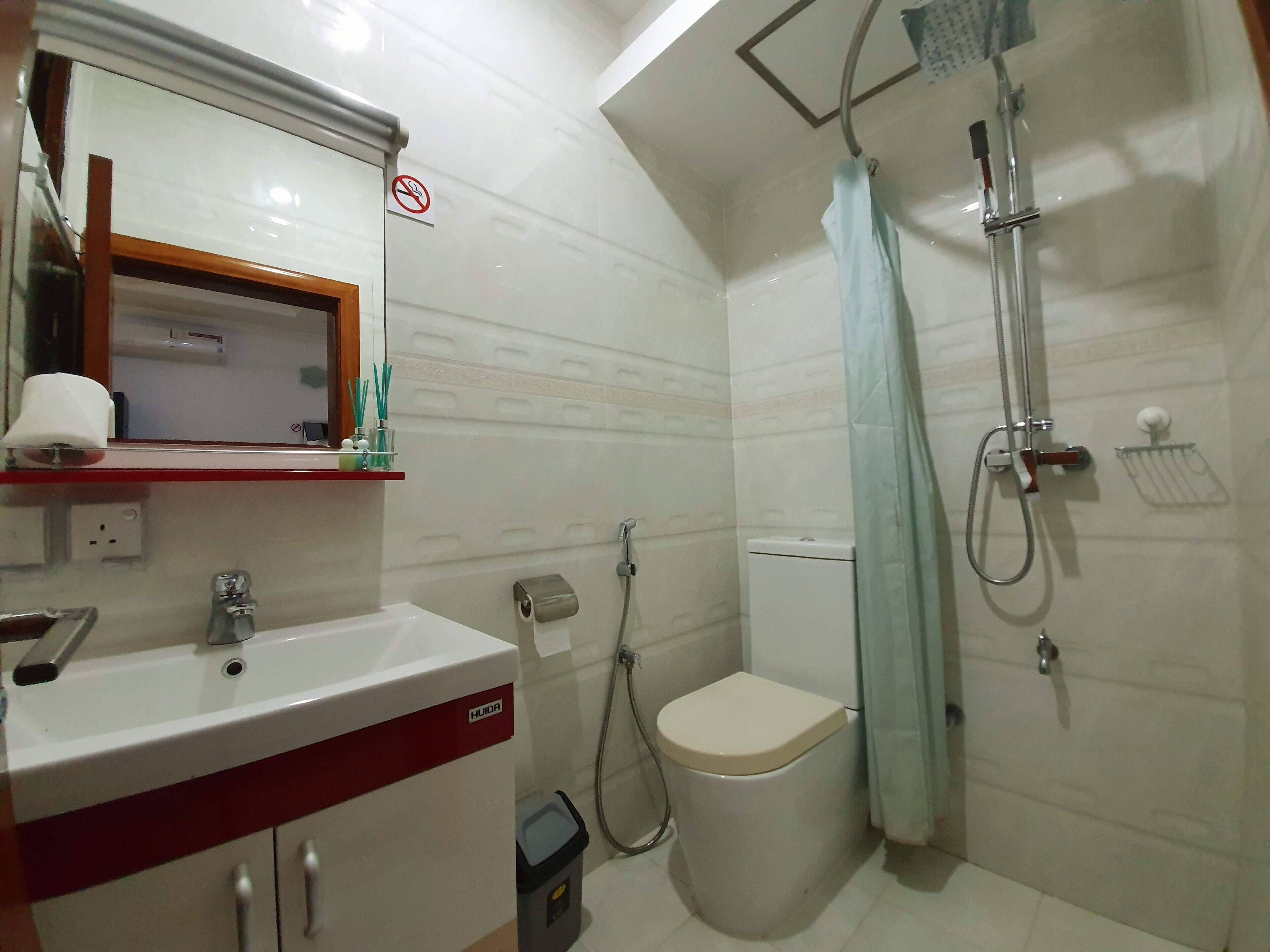 A bathroom with a sink, toilet, and shower.