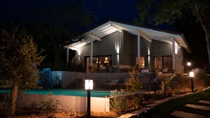 A modern house with a covered patio, a swimming pool, and outdoor furniture. - Ferienhof Eichenberg (Haundorf)