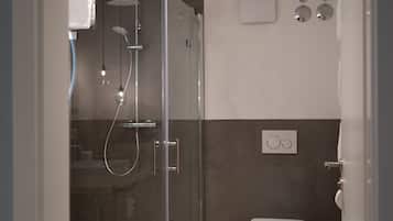 Ein modernes Badezimmer mit einer Duschkabine, einer Toilette und einem Waschbecken.