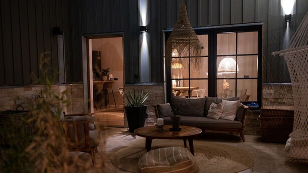 A cozy living room with a sofa, coffee table, and a hanging light fixture. - Ferienhof Eichenberg (Haundorf)