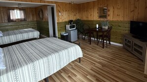 A room with two beds, a small table with chairs, a TV, and a ceiling fan. - Timberline Inn of Grand Lake (Grand Lake)