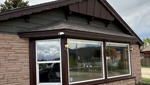 A single-story house with a dark brown roof and large windows. - Timberline Inn of Grand Lake (Grand Lake)