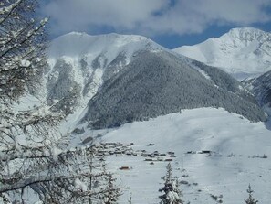 A snow-covered mountain landscape with a small settlement in the valley. - Hôtel Terminus (Orsieres)