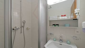 A bathroom with a shower, a sink, and a mirror.