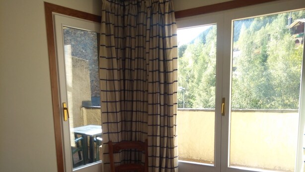 Une pièce avec un lit, une chaise et une fenêtre.