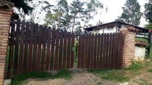 Un espace clos délimité par un mur de briques et une clôture en bois.
