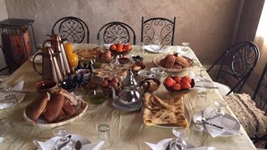A table set for a meal with various dishes, including bread, eggs, and fruit. - Zaid House (Taouz)
