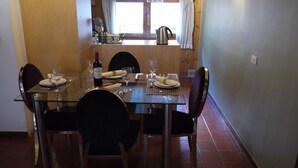 A dining area with a glass table, four chairs, and a window with curtains. - Apartment Mola 19 (Arinsal)