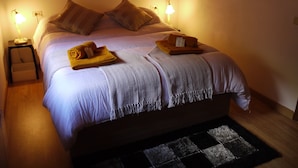 A neatly made bed with pillows, a blanket, and a folded towel on the side. There are two bedside lamps on either side of the bed. - Apartment Mola 19 (Arinsal)