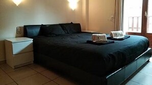 A hotel room with a bed, a nightstand, and a window with curtains. - Apartment Abella 25 (Arinsal)