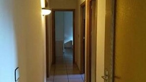 A narrow hallway with tiled flooring and wooden doors on both sides. - Apartment Abella 25 (Arinsal)
