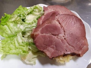 A plate with a slice of ham and a portion of lettuce. - Ferme Auberge du Chèvremont (Orbey)