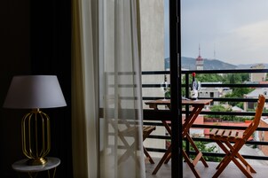 A balcony with a table, chairs, and a lamp.