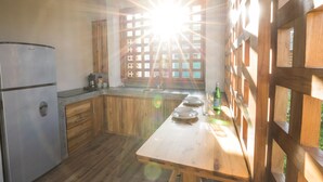 A kitchen with wooden cabinets, a stainless steel refrigerator, and a wooden countertop. - Congo (Nosara)