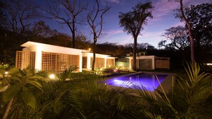 A modern building with a swimming pool, surrounded by lush greenery and trees. - Congo (Nosara)