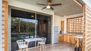 A modern kitchen with a large island, wooden cabinets, and a view of the outdoors. - Congo (Nosara)