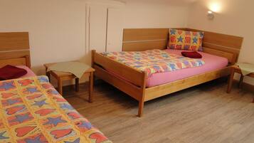 A bedroom with a wooden bed, a wooden desk, and a chair.