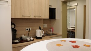 Een moderne keuken met houten kastjes, een koffiezetapparaat, een waterkoker en een spoelbak.