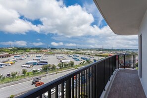 A balcony with a view of a parking lot and a road.