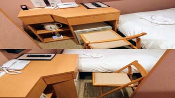 Une chambre d’hôtel de taille réduite, comprenant un lit simple, un petit bureau avec un téléphone, une tasse et une chaise.